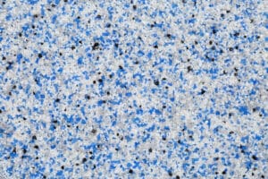 Extreme close up of decorative quartz sand epoxy floor or wall coating with blue, grey, white and black coloured particles